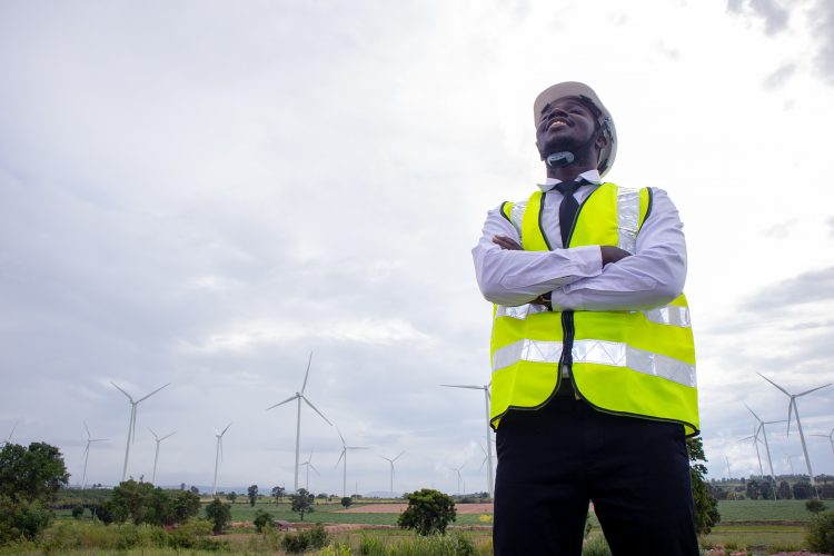 African engineer standing with wind turbine