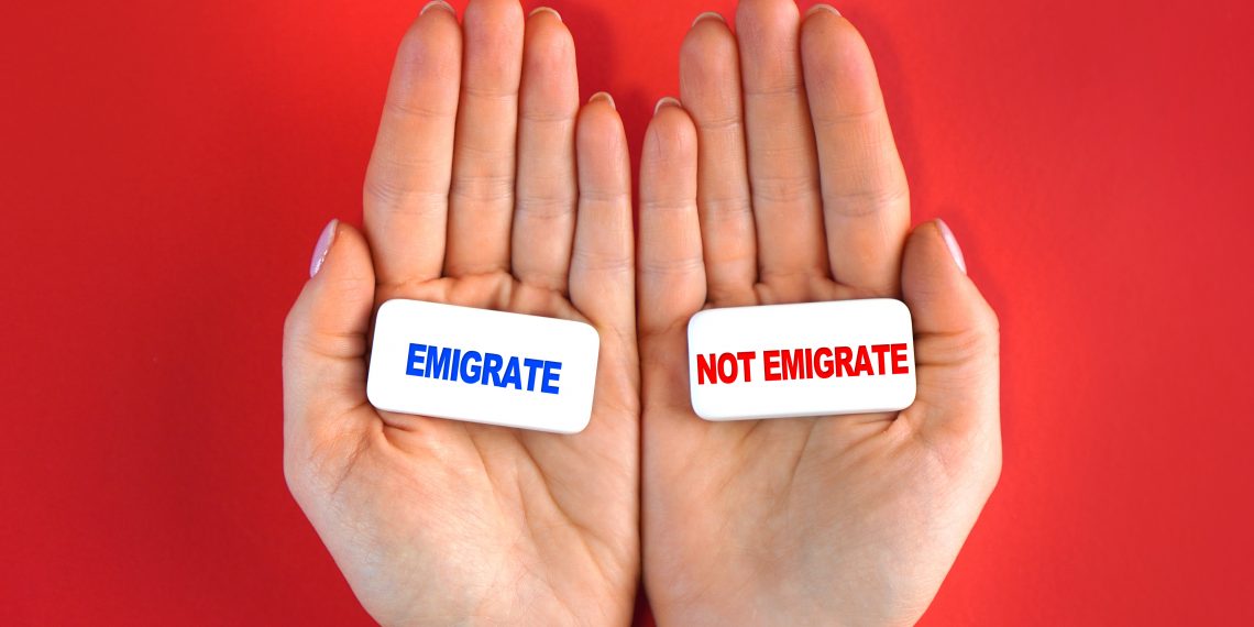 Expat idea. Emigrate or not. Concept with blocks and text in a hands.